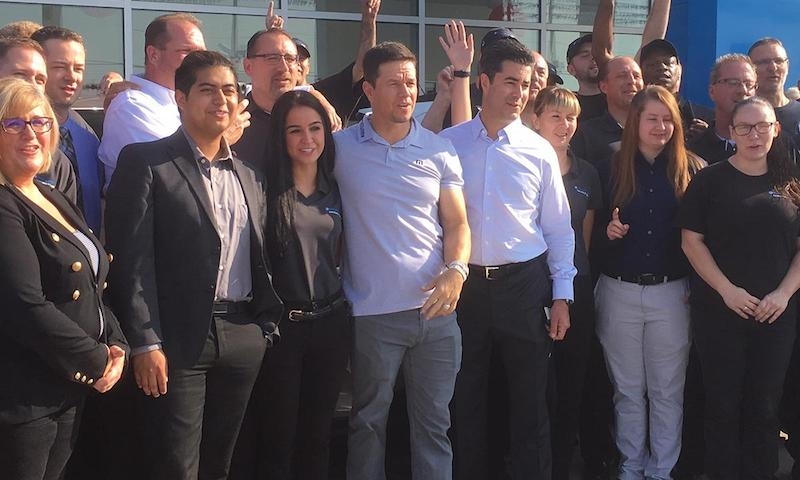 Posing with staff of the dealership at the opening day of Mark Wahlberg Chevrolet